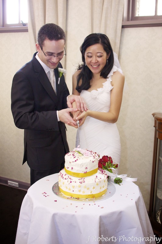 Bride and groom cutting wedding cake - wedding photography sydney